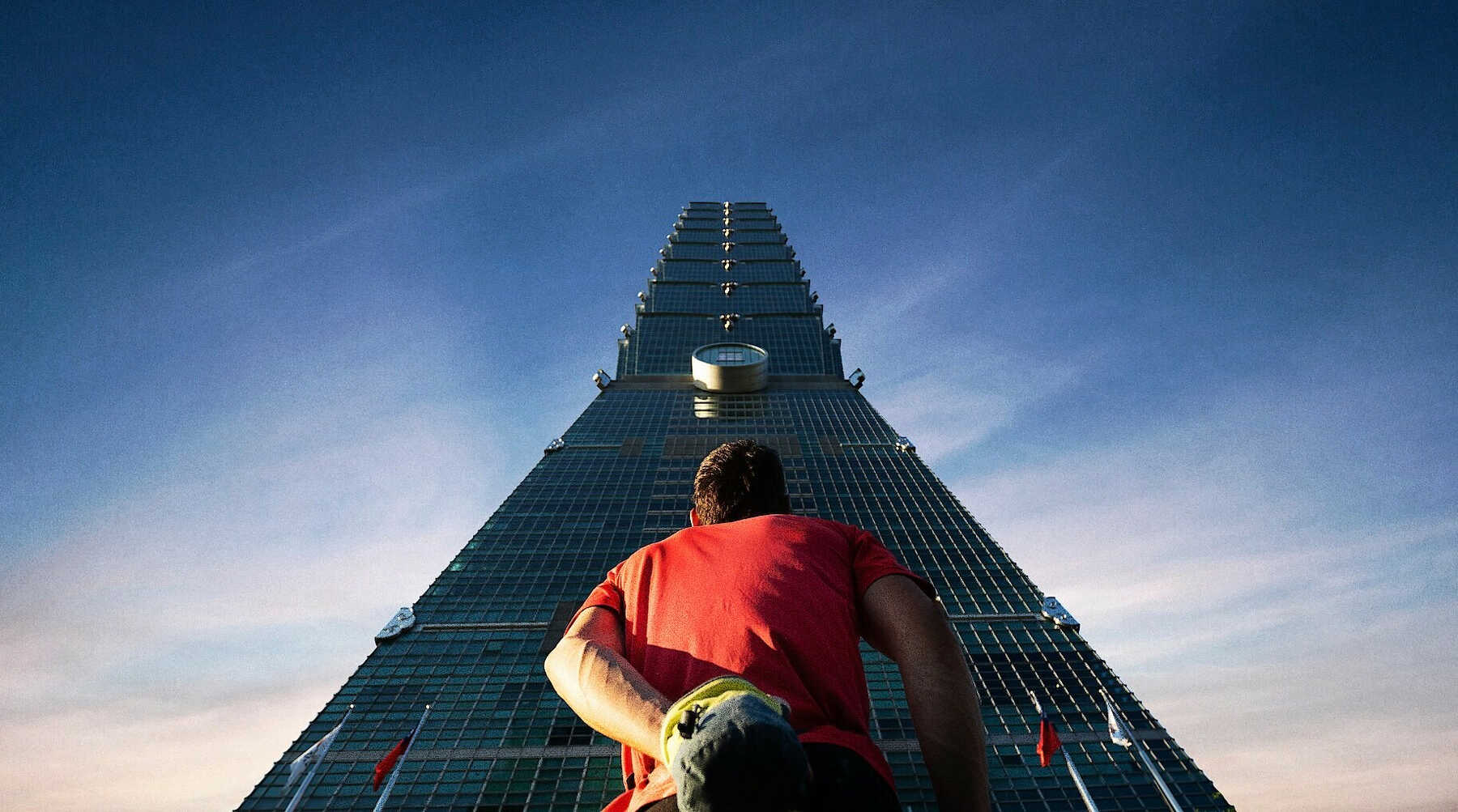 Alex Honnold standing looking up Taipei 101