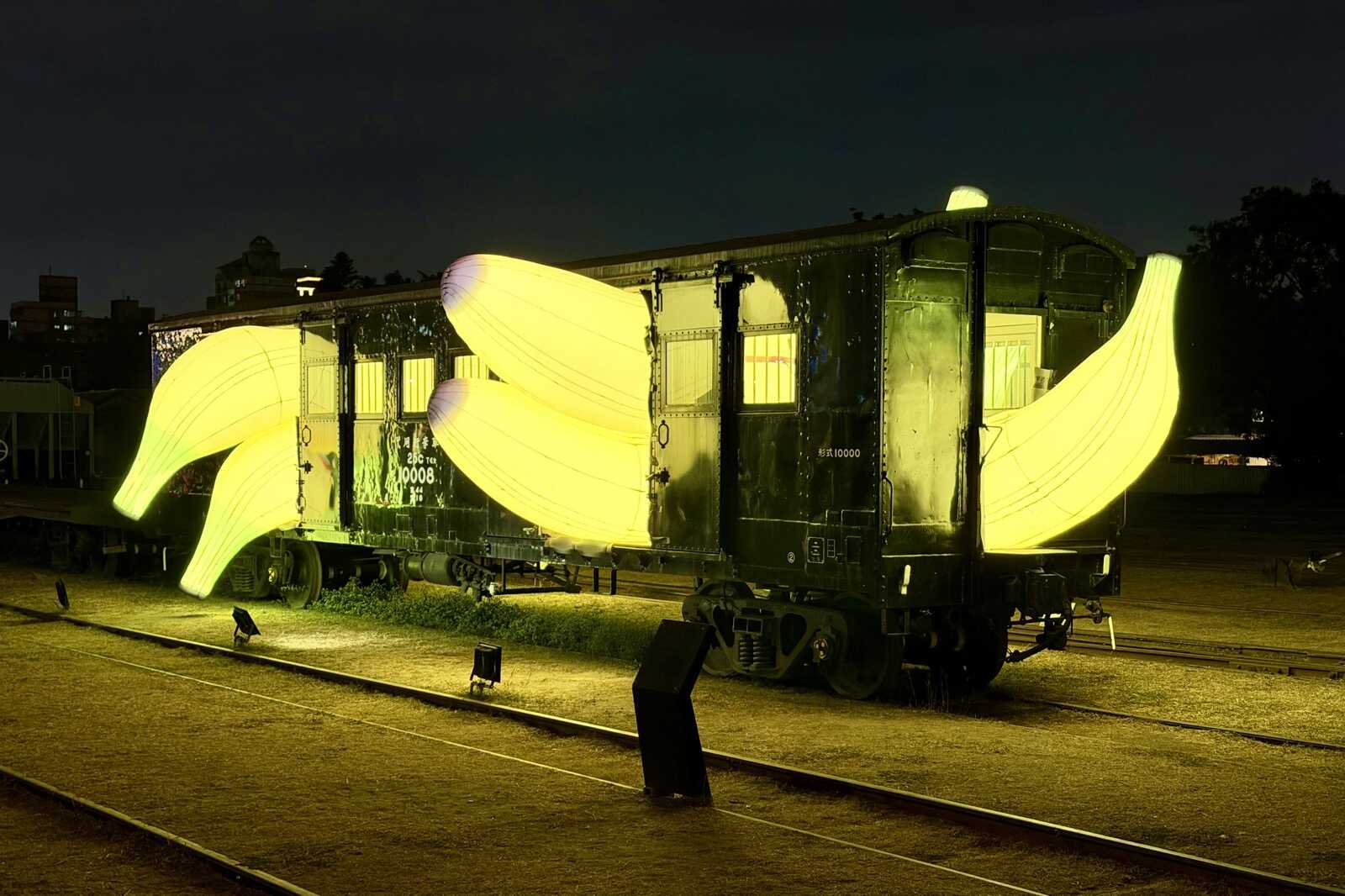 Huge inflatable bananas sticking out of an old train