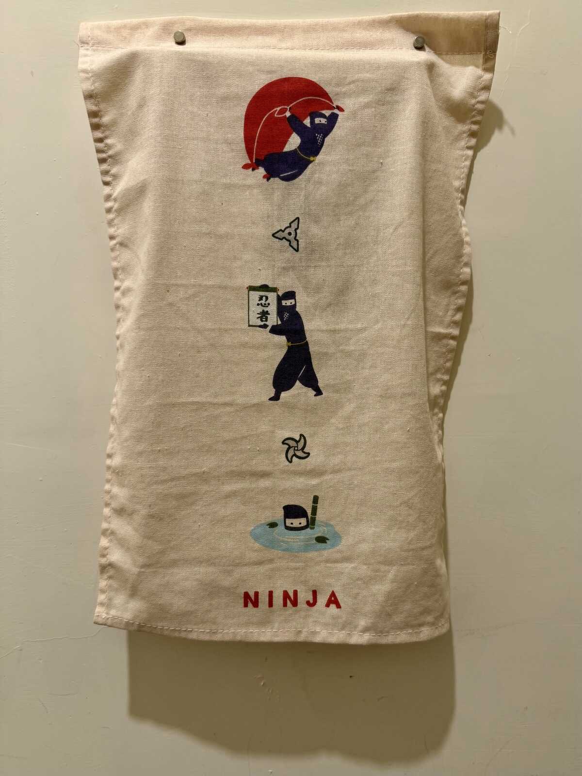 A hanging teatowel with various ninja-related designs on it