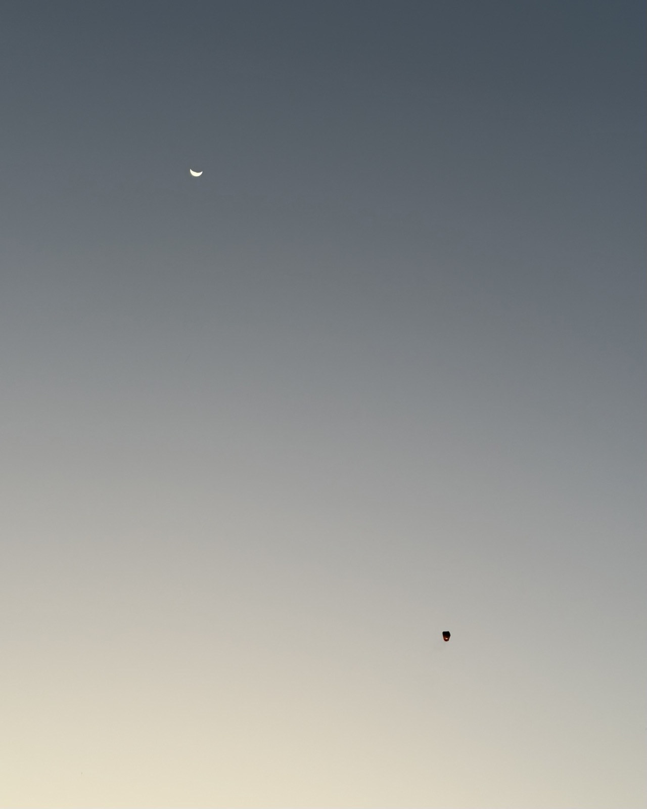 Smiling moon and a single lantern rising into the sky